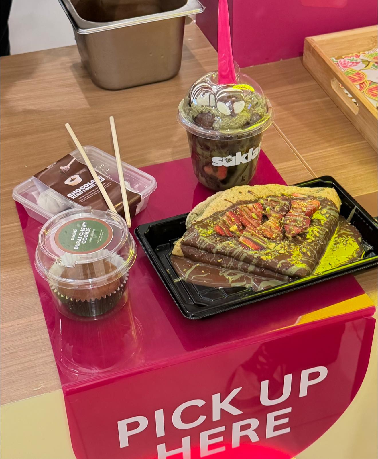 Suklati booth pick-up counter with chocolate xiao long bao, dubai chewy cookie, and dessert cup