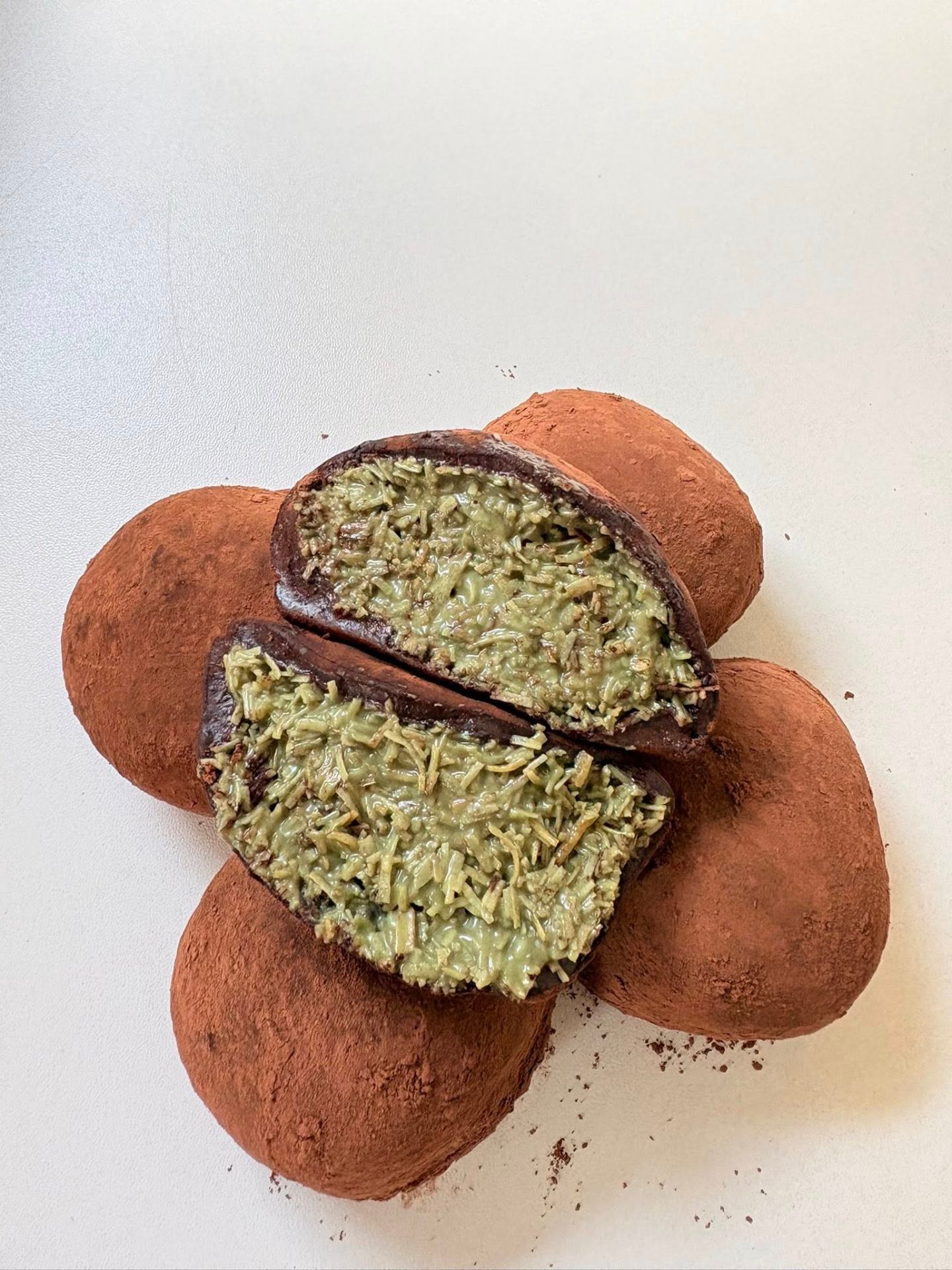 Suklati Chocolate Xiao Long Bao arranged in a flower pattern, one cut open revealing pistachio kunafa filling
